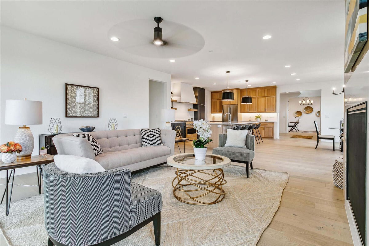 Modern family room with sofa sets, a rug, and a stylish side table lamp in a custom home by Sheffield Homes in Arvada, CO