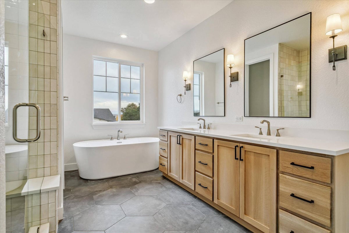 Primary bathroom with a bathtub, stylish dual vanities, and a shower room in a custom home by Sheffield Homes in Arvada, CO