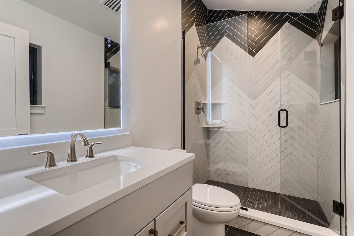 Bathroom with a single vanity, toilet commode, and a shower enclosure in a custom home by Sheffield Homes in Evergreen, CO