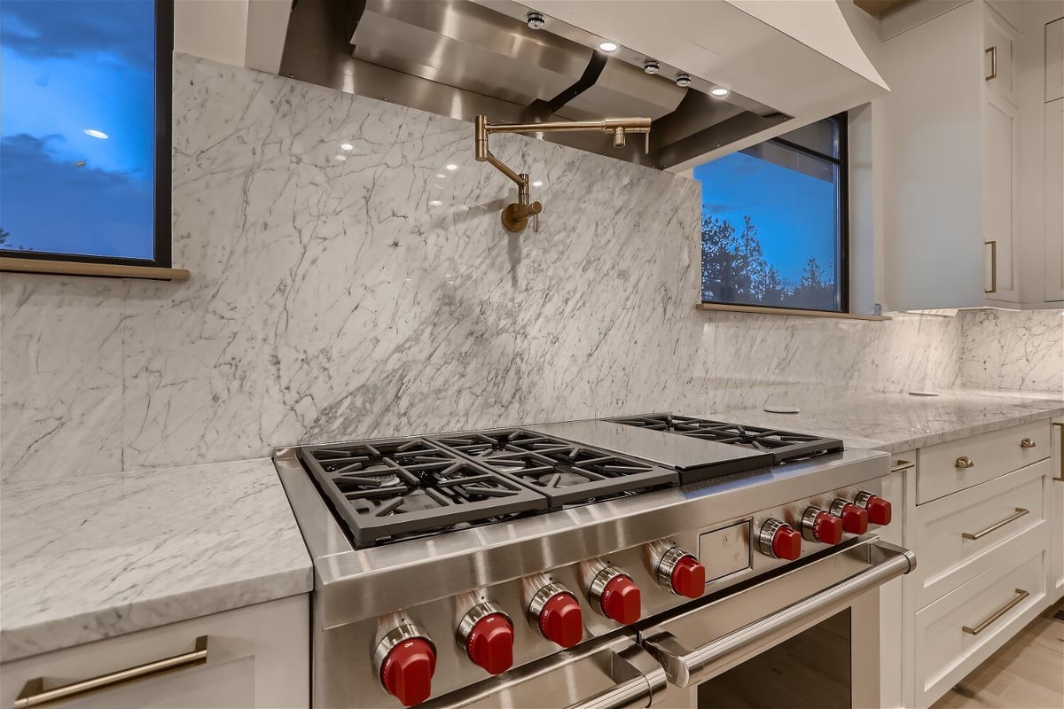 Closeup of stainless steel kitchen stoves and white cabinetry in a custom home by Sheffield Homes in Evergreen, CO