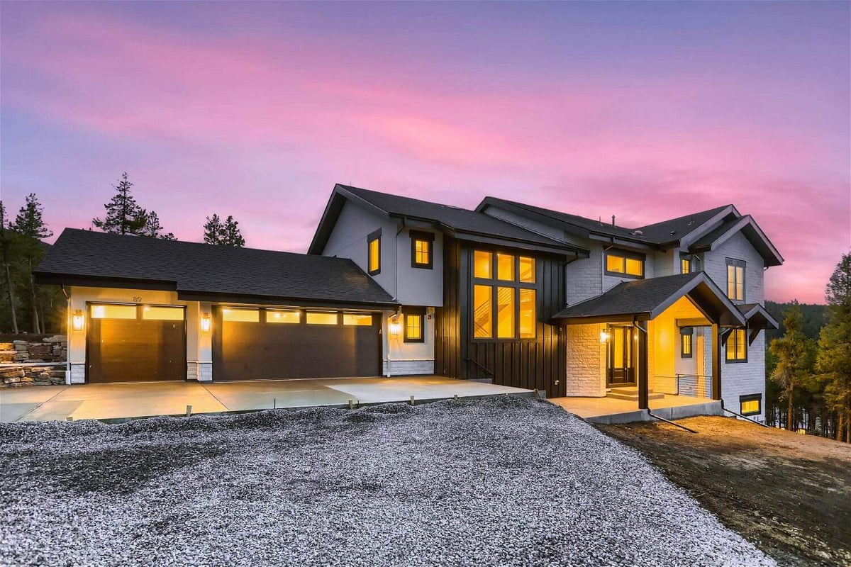 Exterior full rear view of a backyard with elegant lighting outside a custom home built by Sheffield Homes in Evergreen, CO