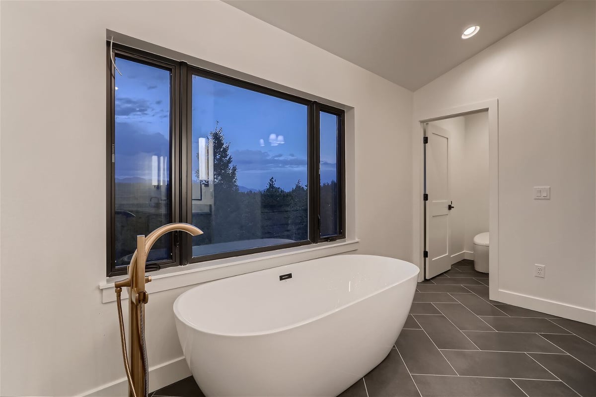 Freestanding bathtub in the second-floor primary bathroom of a custom home by Sheffield Homes in Evergreen, CO