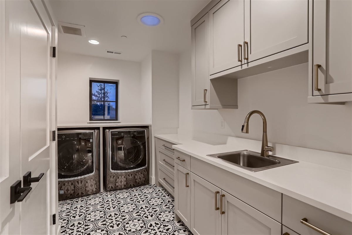 Laundry room featuring a vanity, cabinetry, and washing machines in a custom home by Sheffield Homes in Evergreen, CO