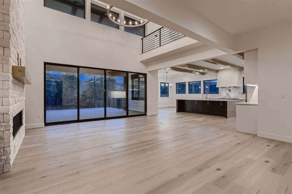 Spacious and modern living room with large sliding doors and windows in a custom home by Sheffield Homes in Evergreen, CO