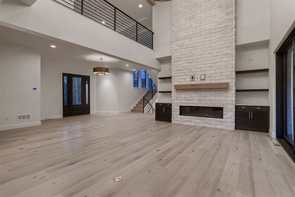 Spacious living room featuring a stone accent wall with a fireplace in a custom home by Sheffield Homes in Evergreen, CO