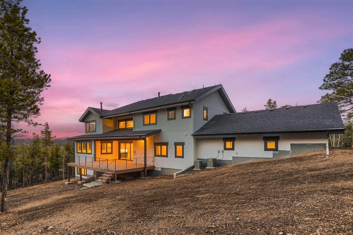 Wide angle shot of the rear exterior of a large backyard outside a custom home built by Sheffield Homes in Evergreen, CO