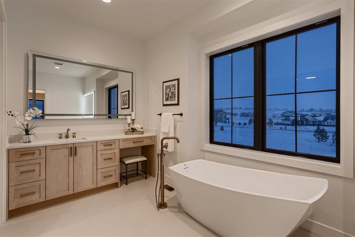Bathroom detailing with a freestanding bathtub and stylish corner vanity in a custom home by Sheffield Homes in Franktown, CO