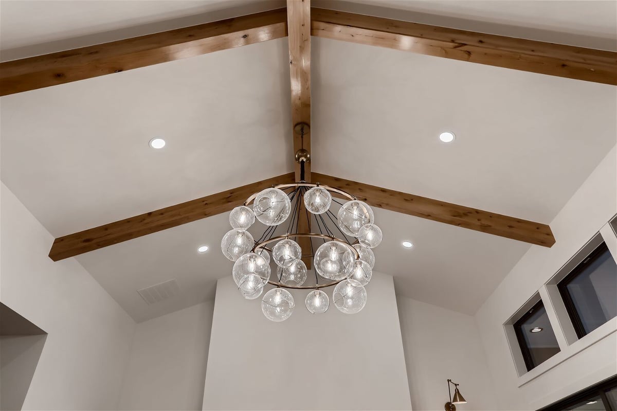 Ceiling detail featuring a fancy chandelier and wooden design in a custom home by Sheffield Homes in Franktown, CO