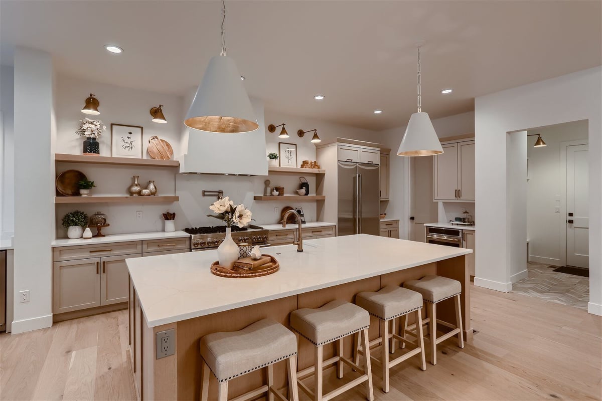 Close-up of a modern kitchen island with dining seats in an open kitchen of a custom home by Sheffield Homes in Franktown, CO
