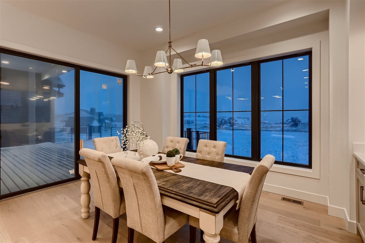 Dining room featuring a modern table and chairs, with sliding windows in a custom home by Sheffield Homes in Franktown, CO