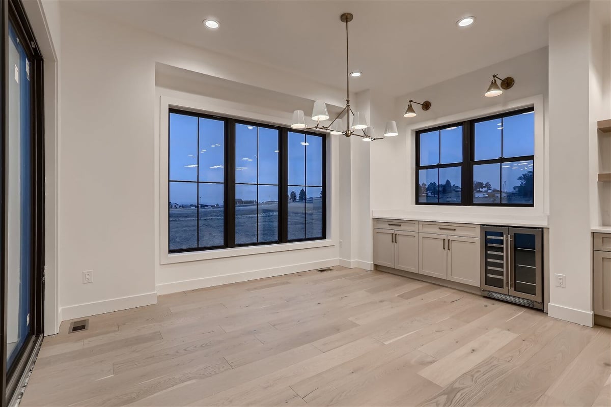 Dining room with a chandelier, cabinets, and sliding windows for fresh air in a home by Sheffield Homes in Franktown, CO