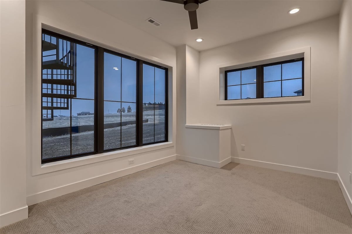 Family room with a ceiling fan, and sliding windows for outside views in a custom home by Sheffield Homes in Franktown, CO