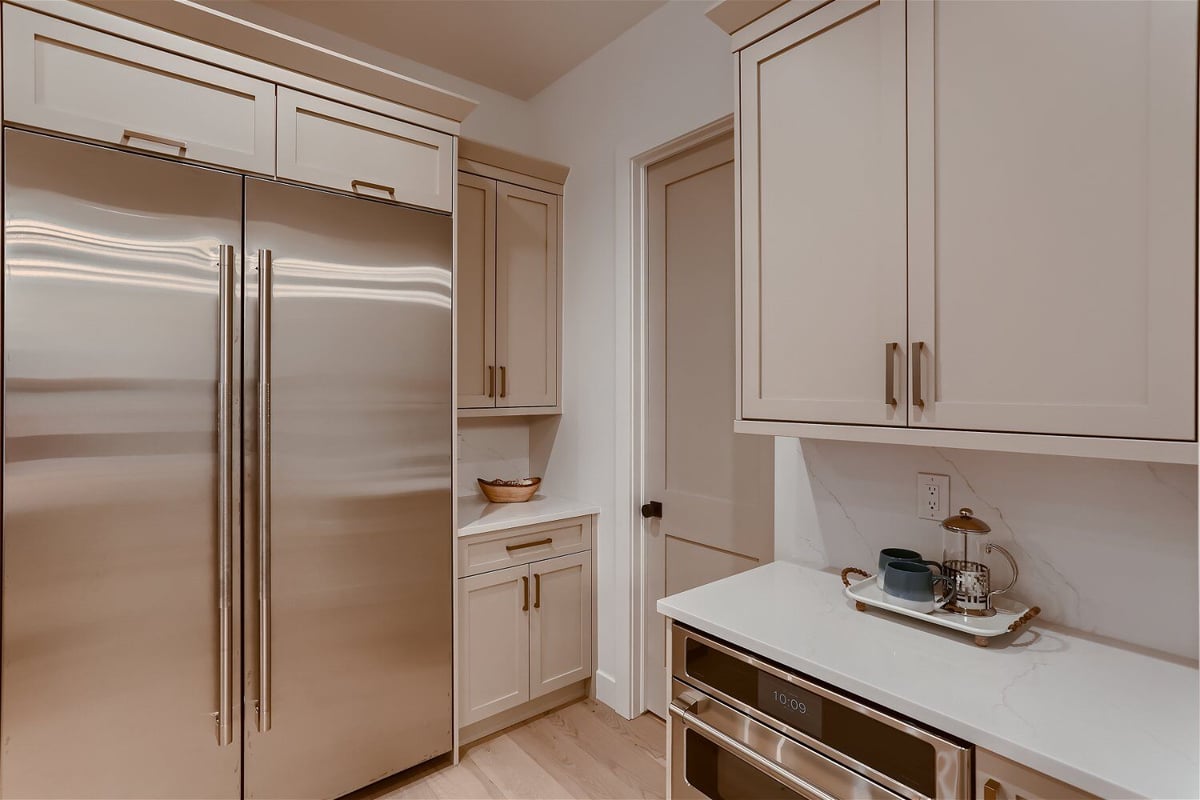 Kitchen detailing with stainless steel appliances and sleek white cabinetry in a Sheffield Homes home, Franktown, CO