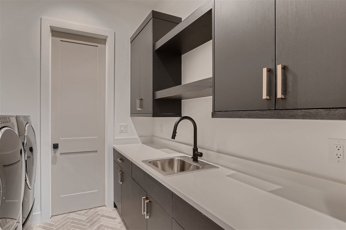 Laundry room with grey and white accents in a custom home built by Sheffield Homes in Franktown, CO
