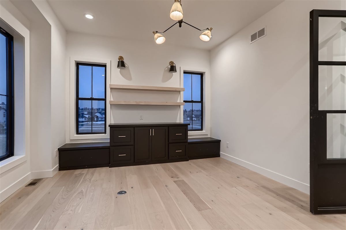 Office space with cabinetry and bookshelves with elegant lighting in a custom home built by Sheffield Homes in Franktown, CO