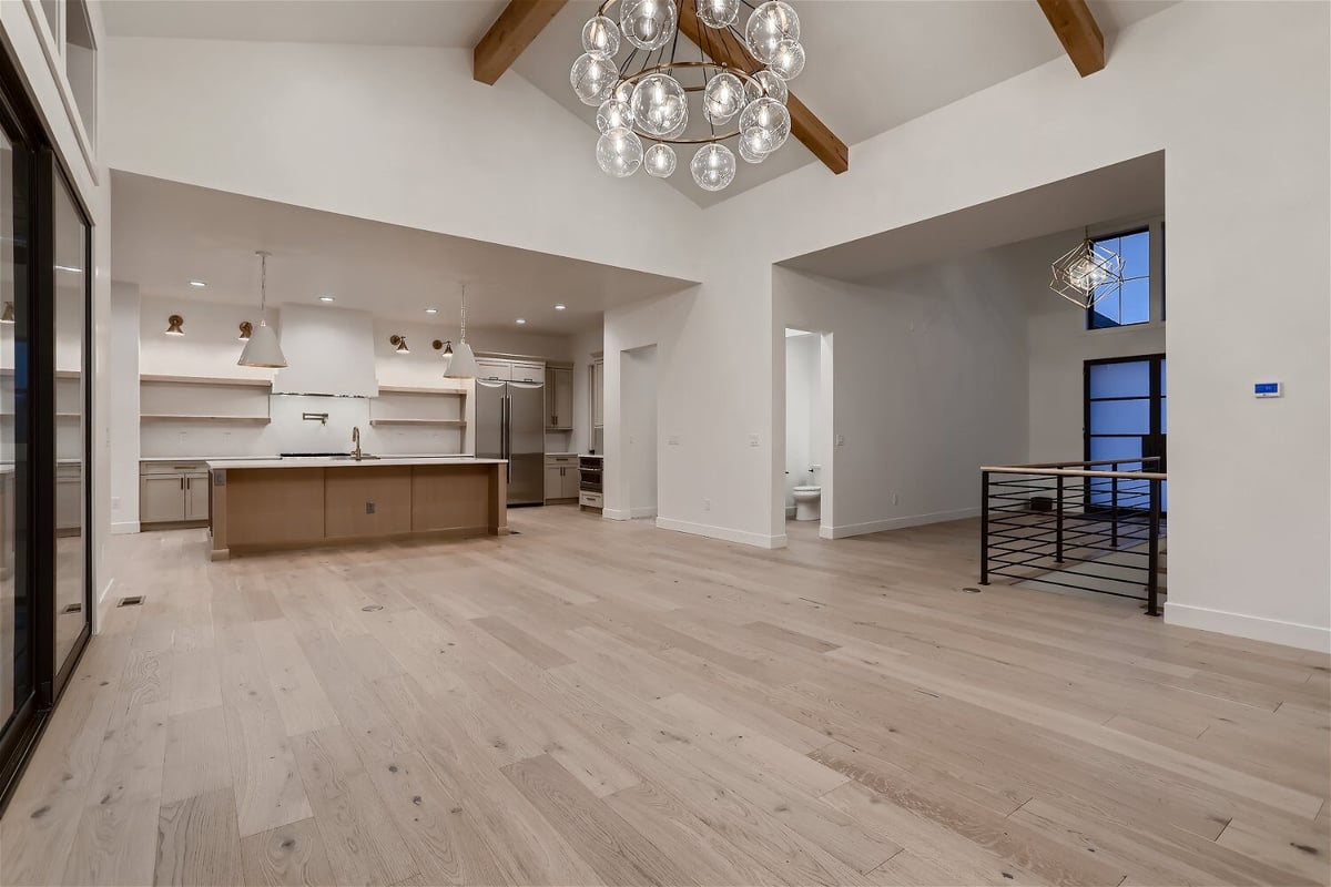 Spacious living room featuring a chandelier, foyer, and open kitchen in a custom home by Sheffield Homes in Franktown, CO