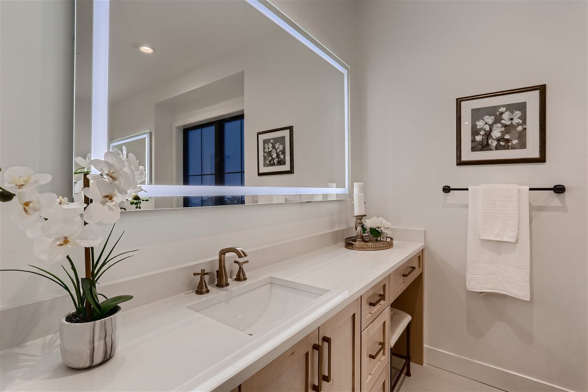 Stylish vanity with a fancy faucet and decor in a bathroom of a custom home by Sheffield Homes in Franktown, CO