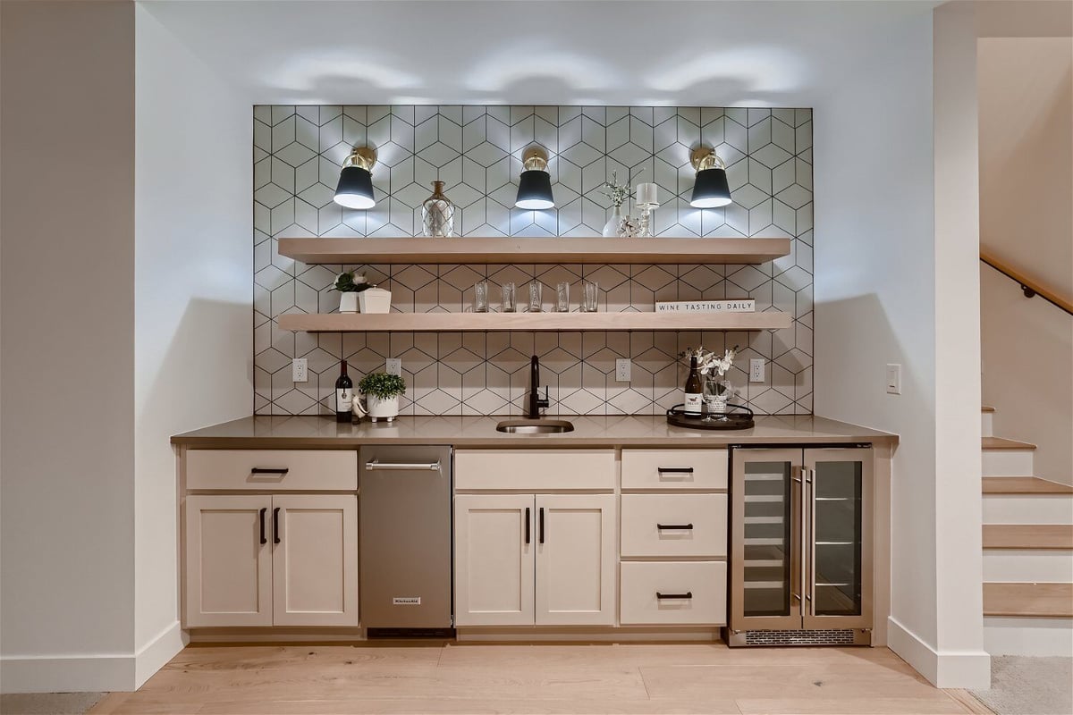 Wetbar with all its essentials, cubic wall design, and elegant lighting in a custom home by Sheffield Homes in Franktown, CO