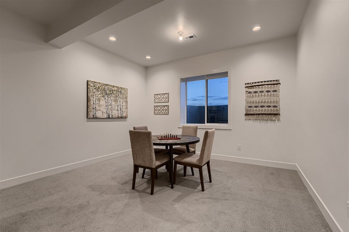 A round table with four seats and a chess game board in a basement of a custom home by Sheffield Homes in Franktown, CO