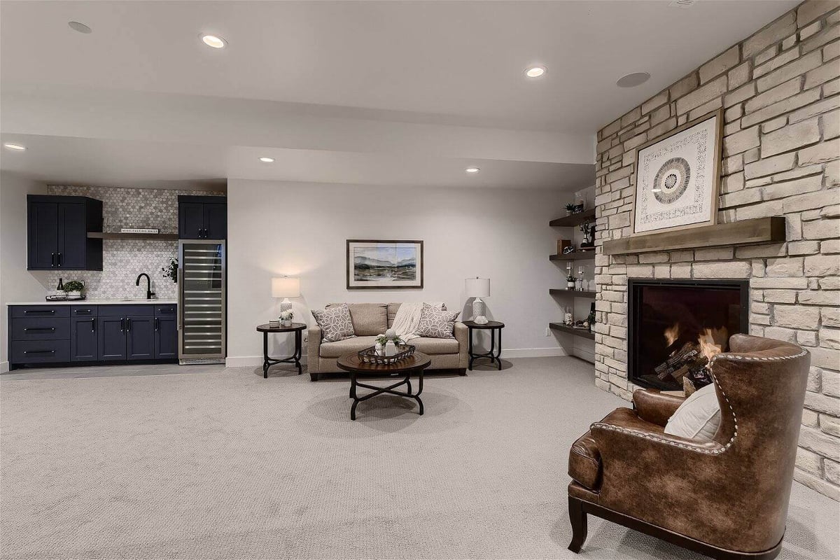 Basement with carpet flooring and a sitting area next to a fireplace in a custom home by Sheffield Homes in Franktown, CO-1