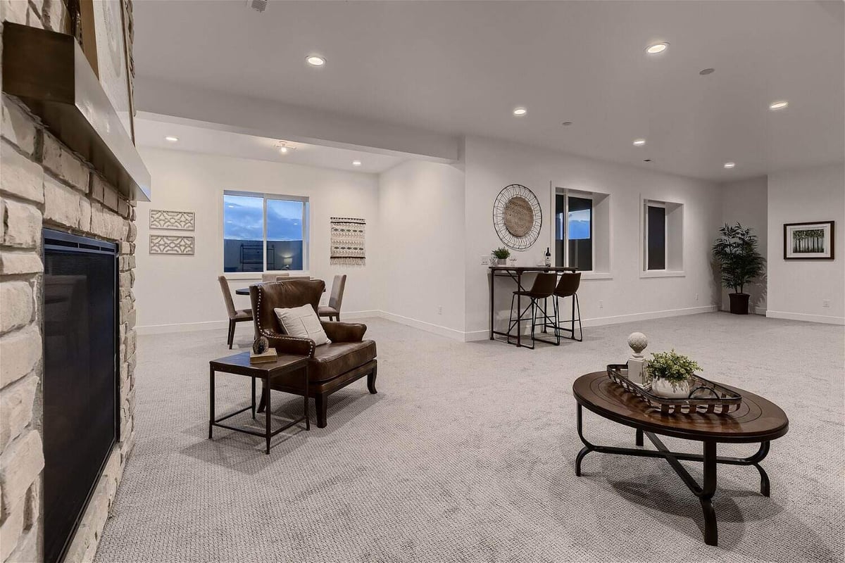 Basement with carpet flooring, a sofa chair, and a couple of tables in a custom home by Sheffield Homes in Franktown, CO
