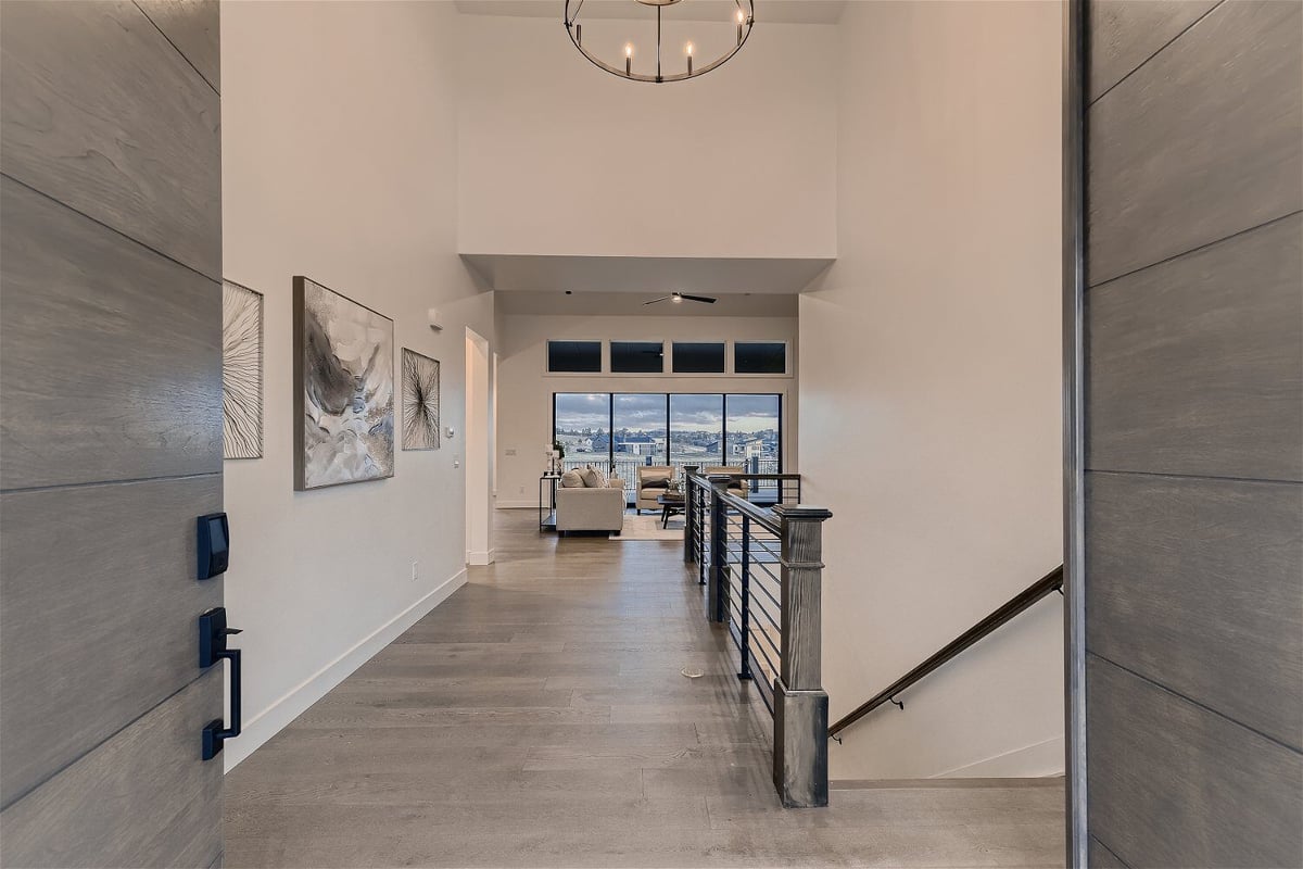 Elegant grey accent wooden door with a view of the foyer in a custom home by Sheffield Homes in Franktown, CO