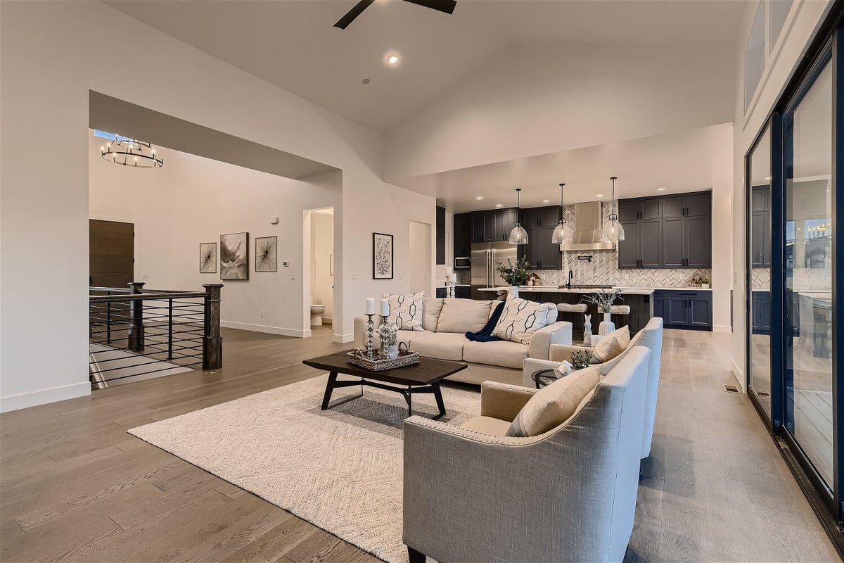 Living room with sofas and a floor rug adjacent to the foyer in a custom home by Sheffield Homes in Franktown, CO