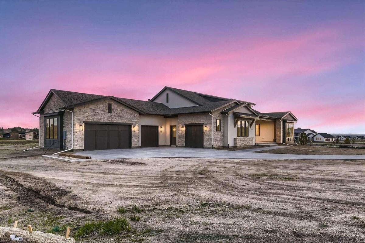 Low-angle exterior front view of a large custom home with a front yard built by Sheffield Homes in Franktown, CO