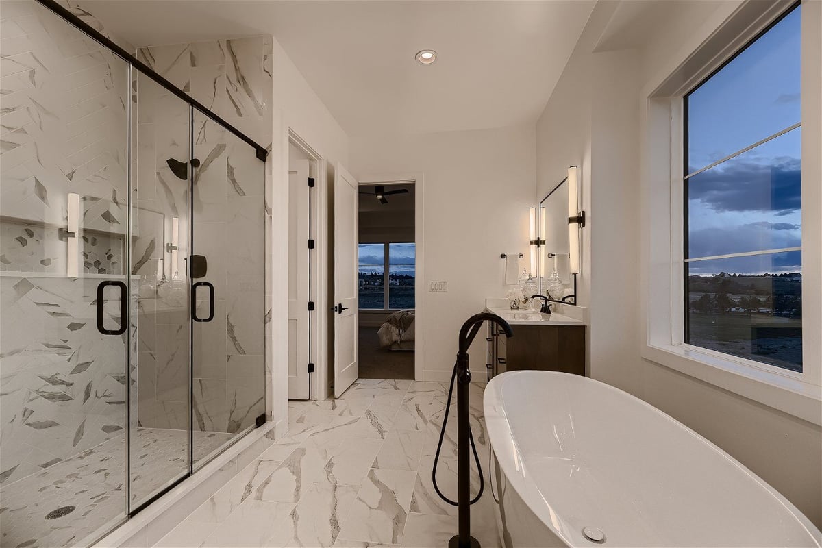 Primary bathroom with a shower area, bathtub, and freestanding tub faucet in a custom home by Sheffield Homes, Franktown, CO