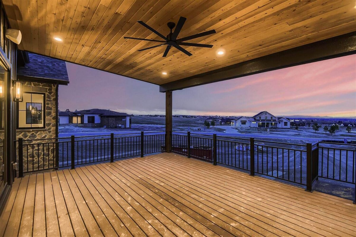 Deck with elegant lighting fixtures, a ceiling fan, and expansive outdoor views in a home by Sheffield Homes in Franktown, CO