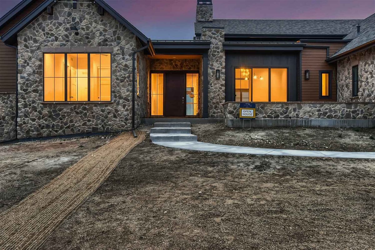 Low light exterior front entrance of a custom home with a walkway by Sheffield Homes in Franktown, CO