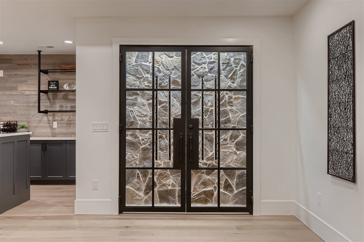 Lower-level adega next to an open kitchen in the main living room of a custom home by Sheffield Homes in Franktown, CO