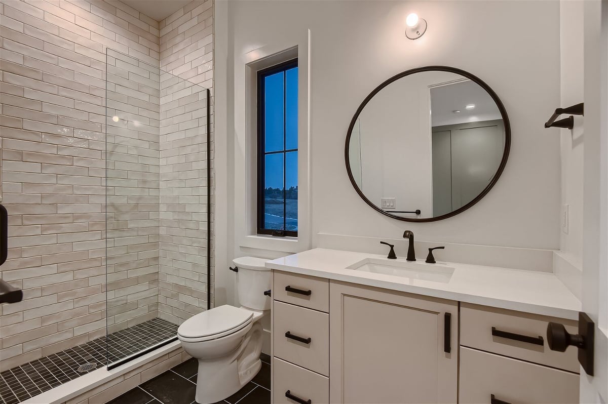 Modern white-themed bathroom with a minimal design and elegant lighting in a custom home by Sheffield Homes in Franktown, CO