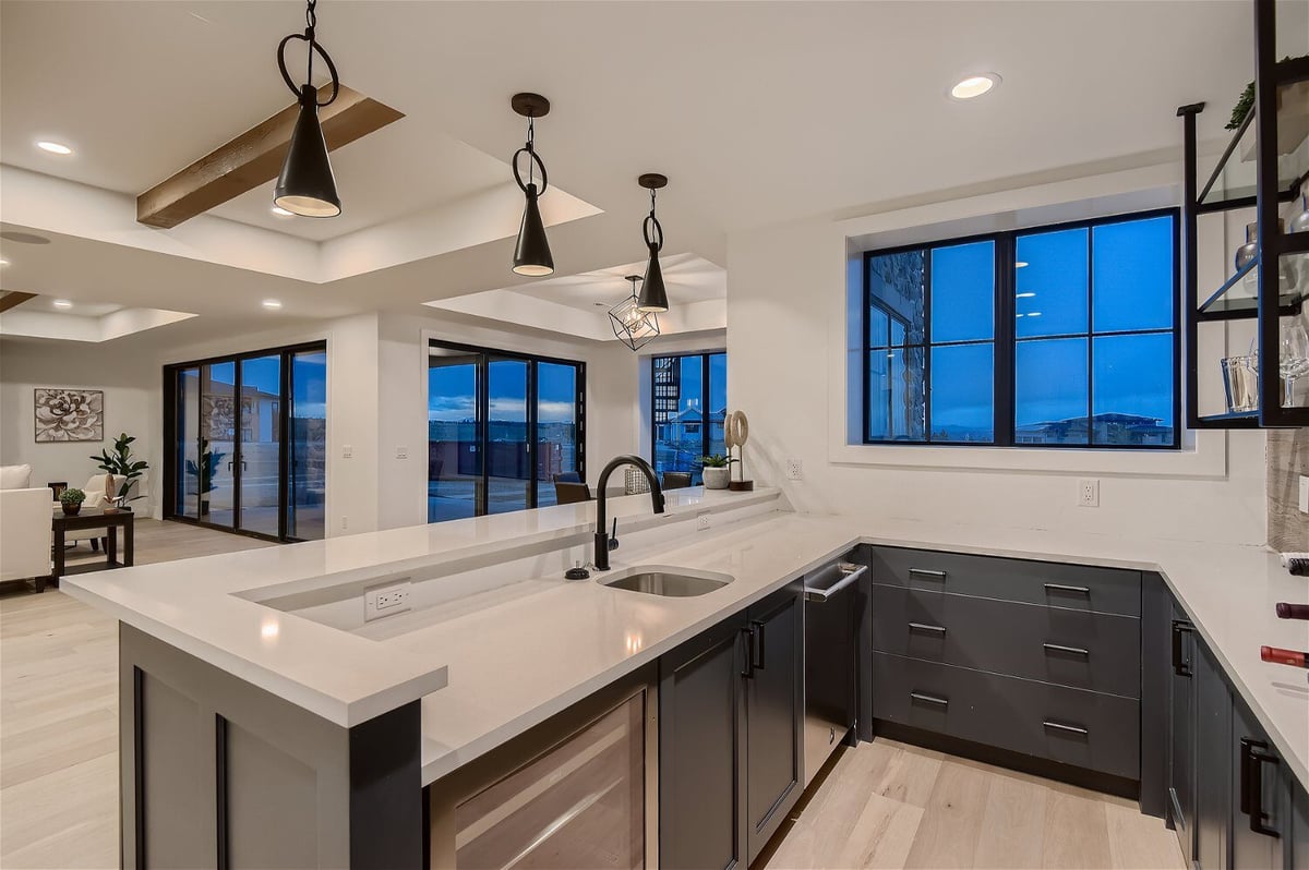 Open kitchen island with steel and wooden base and sleek countertop in a custom home by Sheffield Homes in Franktown, CO