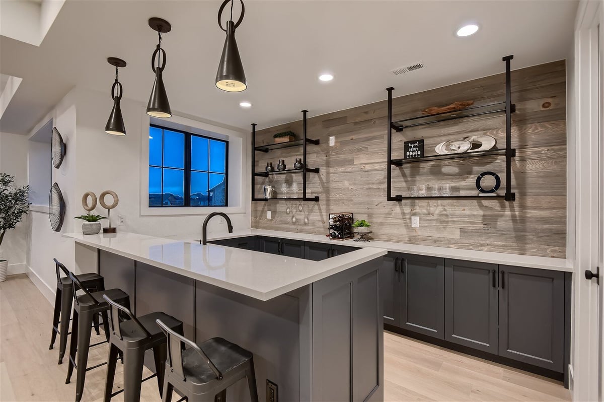 Premium grey-themed kitchen with an island, seating, and all essentials in a custom home by Sheffield Homes in Franktown, CO