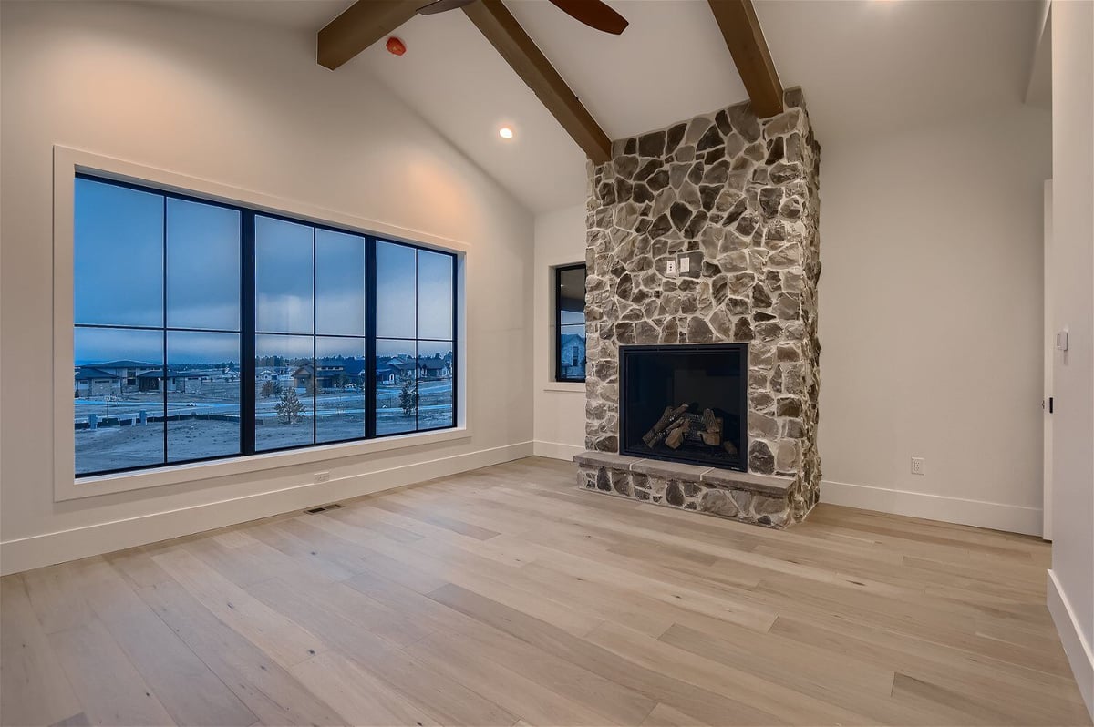 Primary bedroom with a custom wall, a fireplace, and sliding windows in a custom home by Sheffield Homes in Franktown, CO
