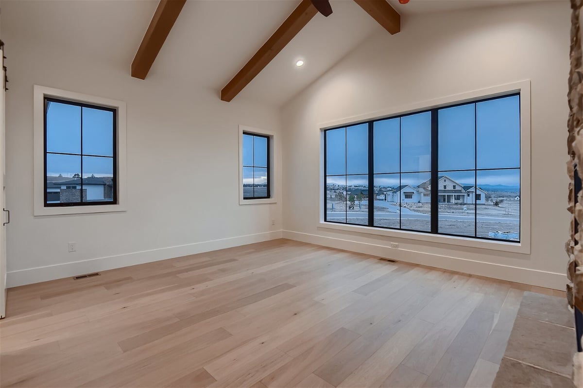 Primary bedroom with wooden ceiling craft and sliding windows in a custom home by Sheffield Homes in Franktown, CO