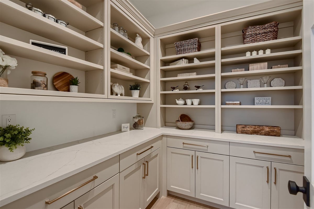 White-themed butler_s pantry with kitchen and household storage in a custom home by Sheffield Homes in Franktown, CO