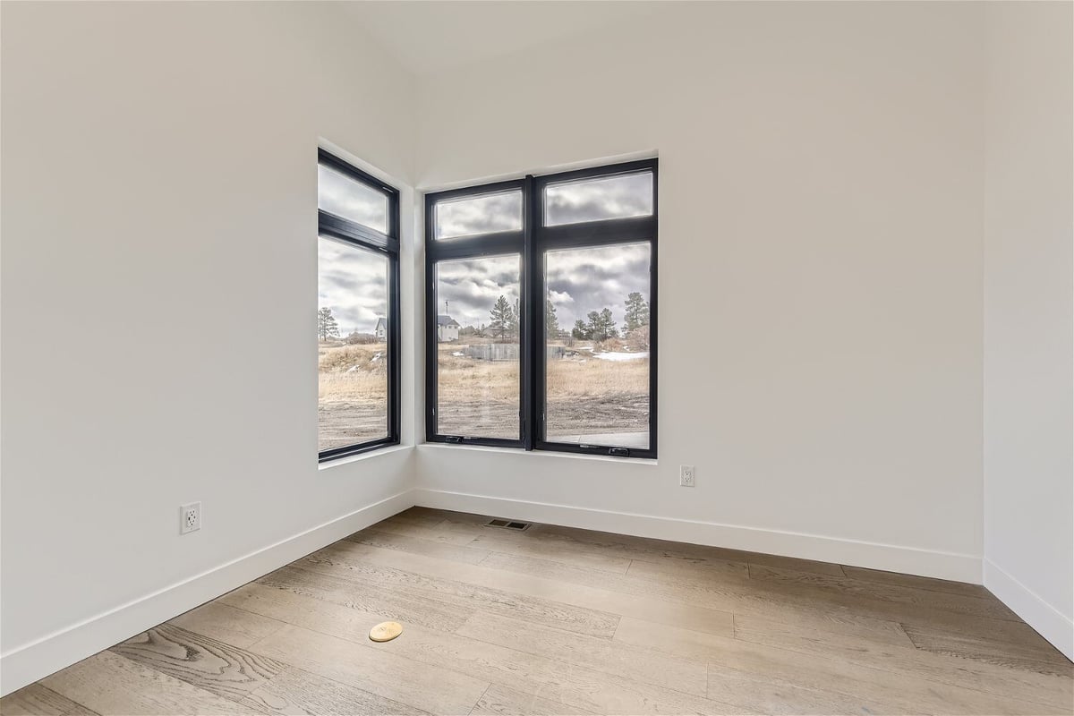 Bedroom with two sliding windows and marble flooring in a custom home project by Sheffield Homes in Franktown, CO