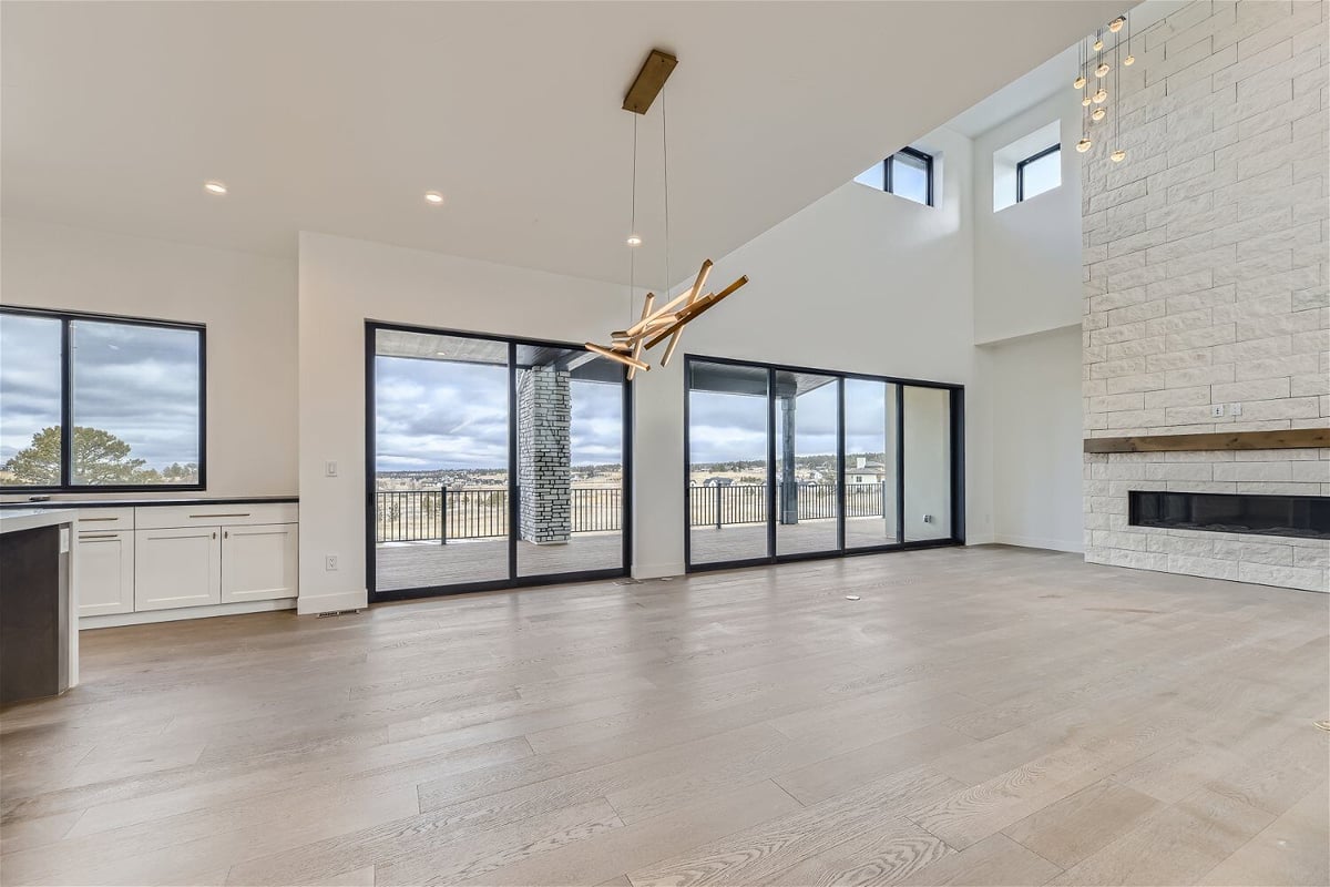 Breakfast area with a bright chandelier, sliding doors, and windows in a custom home by Sheffield Homes in Franktown, CO