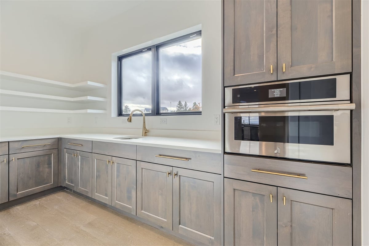 Butler_s pantry with a sink and gross cabinetry for storage in a custom home by Sheffield Homes in Franktown, CO