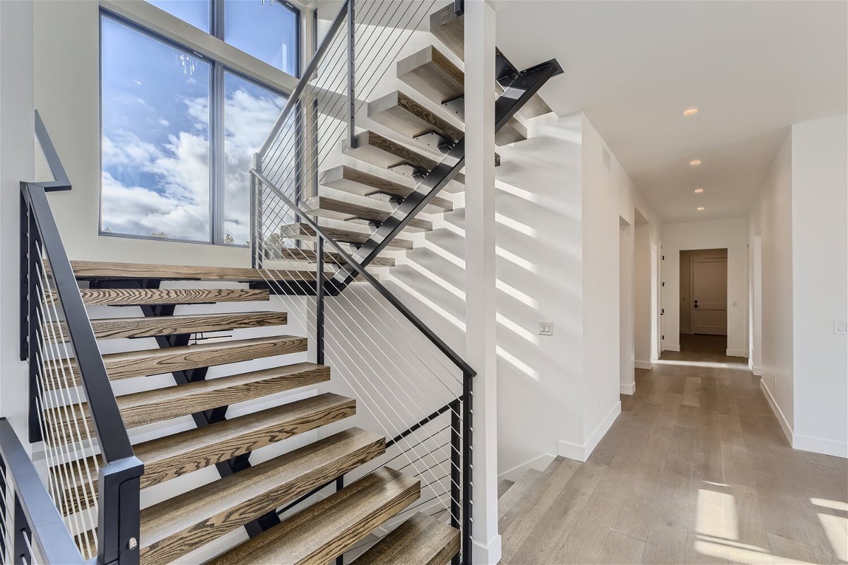 Close-up of a double stairway with wooden steps and metal railings in a custom home by Sheffield Homes in Franktown, CO