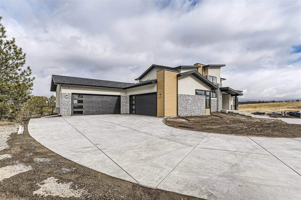 Exterior side-front of a custom home with stone accent walls and a front pathway in Franktown, CO, built by Sheffield Homes