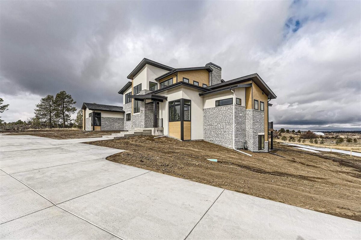 Exterior side-front shot of a custom home with stone accent work and a front pathway by Sheffield Homes in Franktown, CO