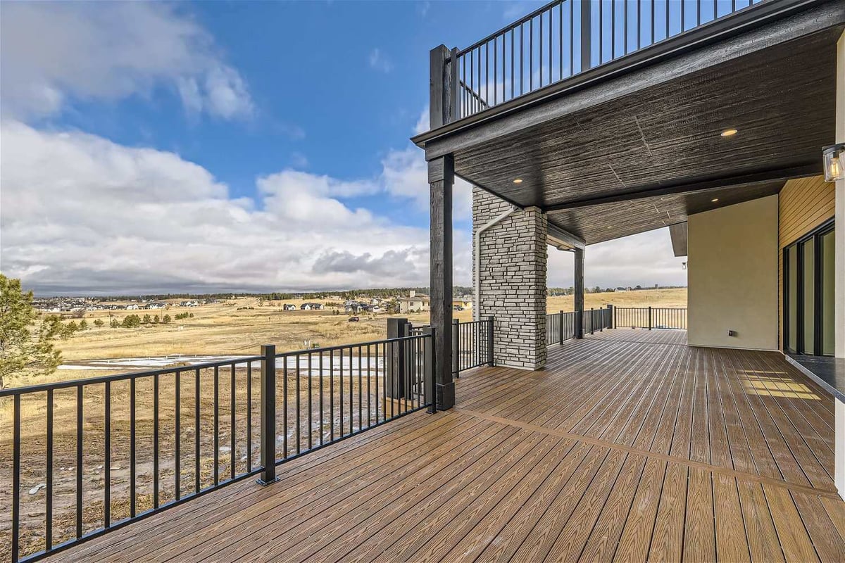 Spacious private balcony with a metal fence and a top deck in a custom home by Sheffield Homes in Franktown, CO