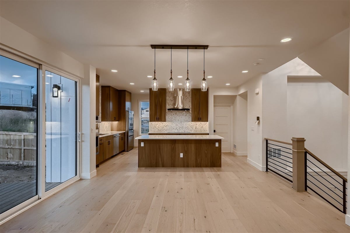 Breakfast area with large sliding doors and an open kitchen in a custom home by Sheffield Homes in Louisville, CO