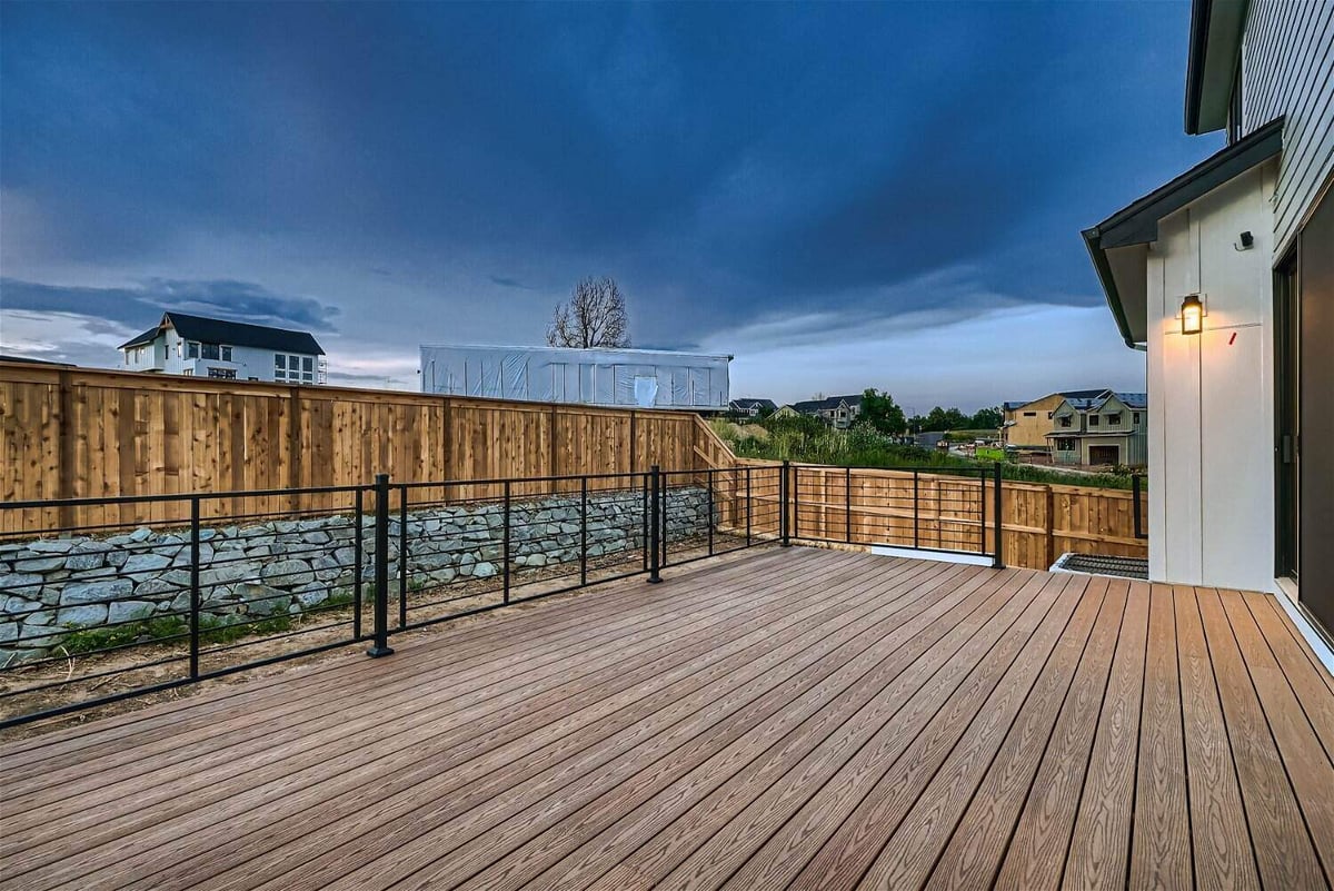 Custom deck with black metal fence extending from the living room in a custom home by Sheffield Homes in Louisville, CO