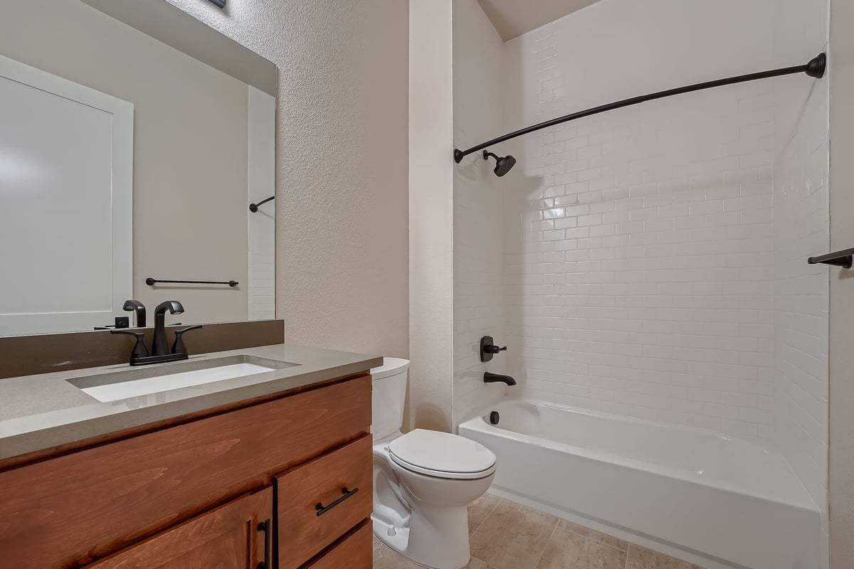 Bathroom with subway tile shower and single vanity in a Denver custom home by Sheffield Homes