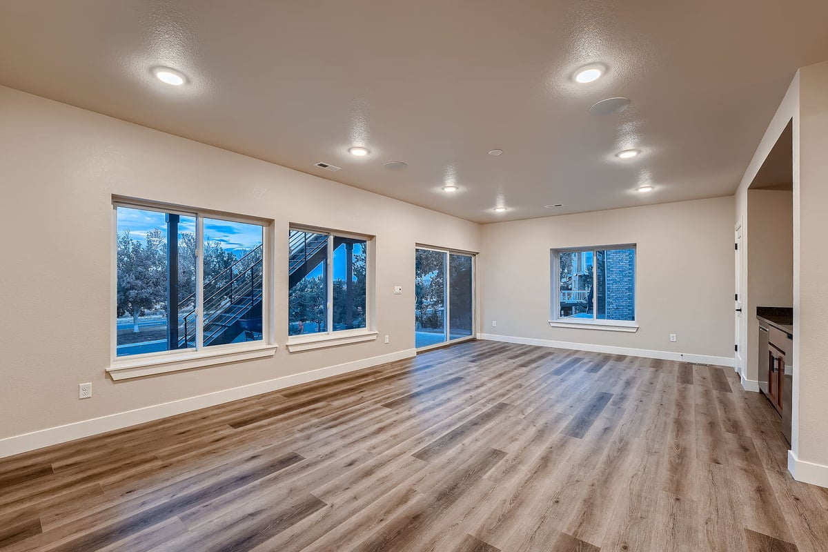 Bright family room with large windows and wood flooring in a Sheffield Homes custom Denver home