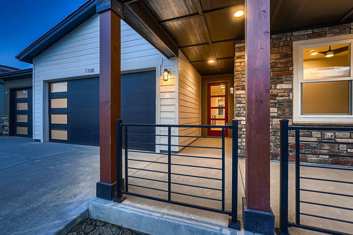 Close-up of front entry of a custom home by Sheffield Homes in Denver, CO, with stone accents and warm lighting